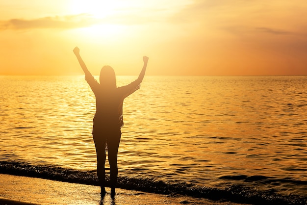 Silhouette of cheerful woman on the beach