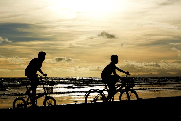 Silhouette of a child riding a bicycle on the beach