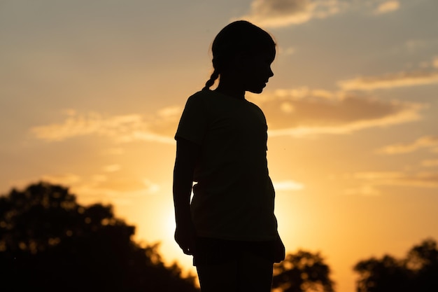 Silhouette of a child in sunlight rays Little girl enjoying life and nature