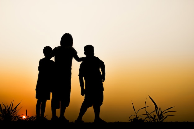 Foto silhouette di bambini con sfondo bellissimo tramonto.