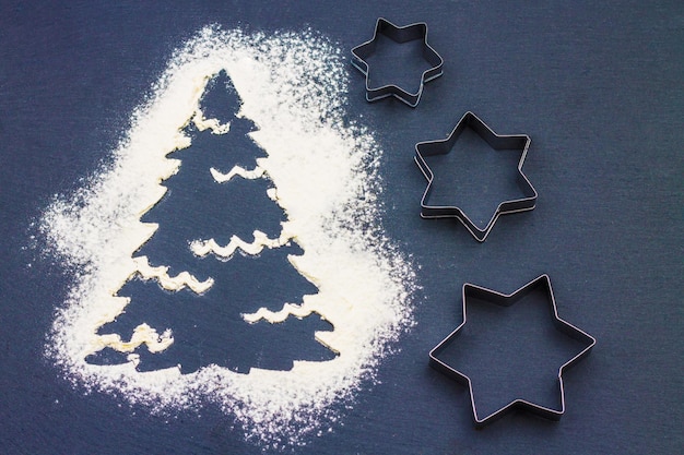 Silhouette of a Christmas tree made of flour on a gray background