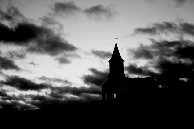 Silhouette church against cloudy sky