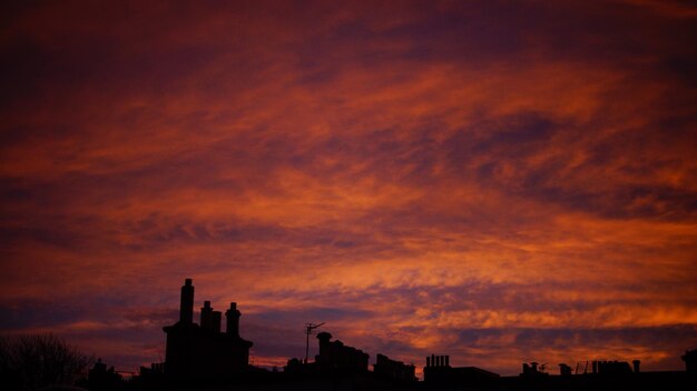 Silhouette of city against sky at sunset