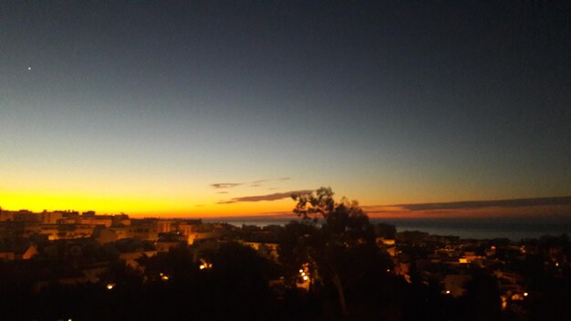 Silhouette cityscape against sky at night