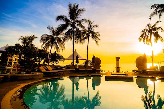 Silhouette coconut palm tree around swimming pool