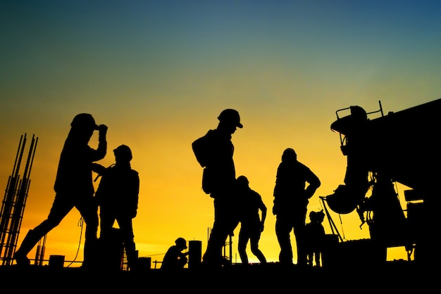 Photo silhouette construction worker concrete pouring during commercial concreting floors of building in construction site