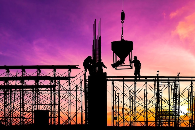 Silhouette of construction workers are working on high ground at construction site