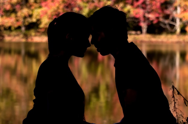 Silhouette of couple in love in front of colorful lake