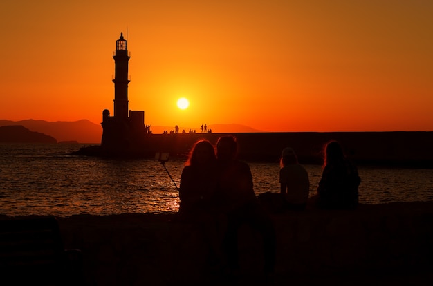 Silhouette of  couple making selfie on beach at sunset in city of Chania