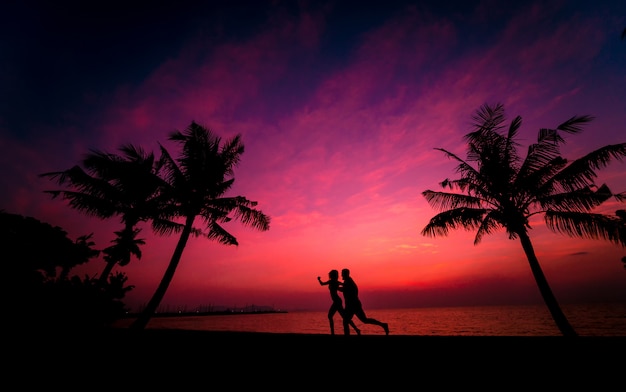 Silhouette of couple on tropical beach during sunset