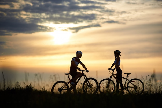 Silhouette of couple with bikes