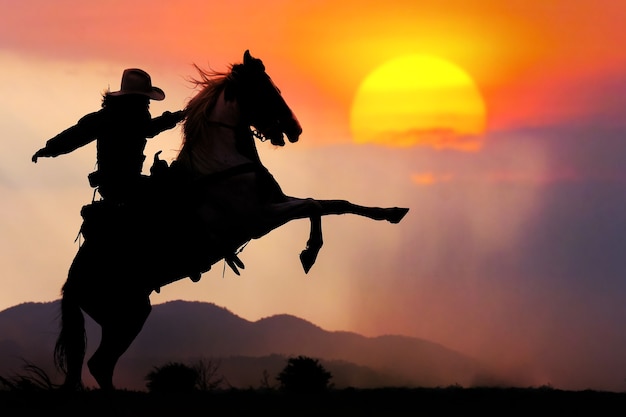 Photo the silhouette of the cowboy and the setting sunset