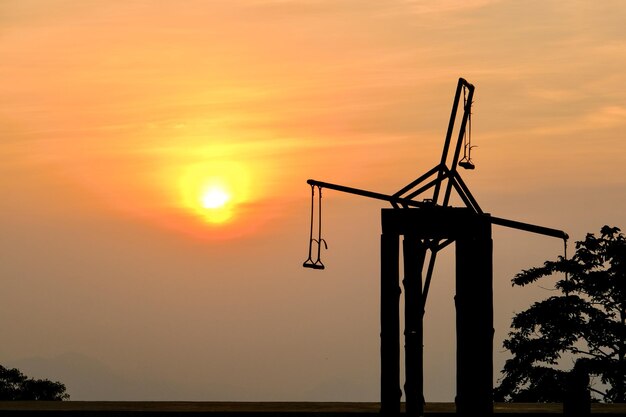 Silhouette crane against sky during sunset