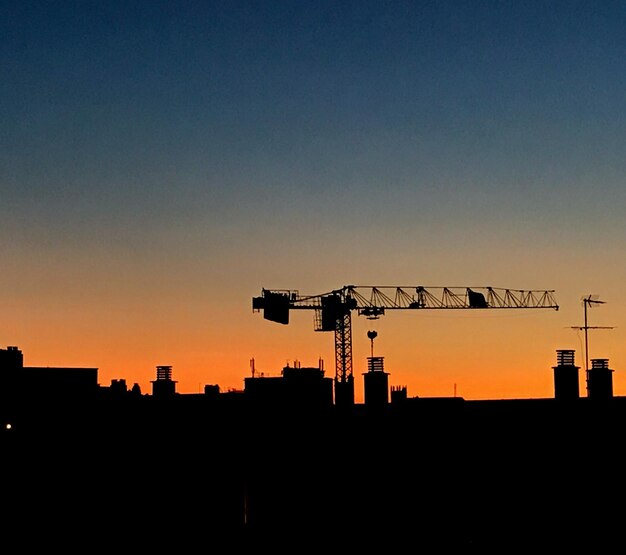 Photo silhouette crane against sky during sunset