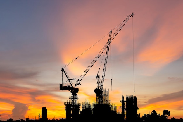 Silhouette of Crane and building construction site sunset sky in evening time