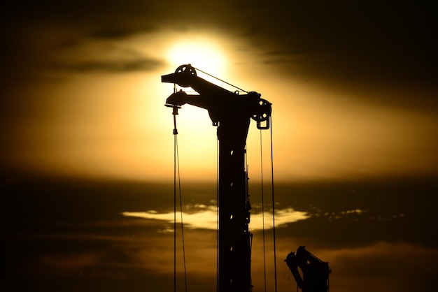 Photo silhouette crane by sea against sky during sunset