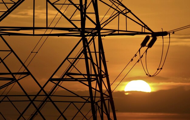 Photo silhouette cranes against sky during sunset