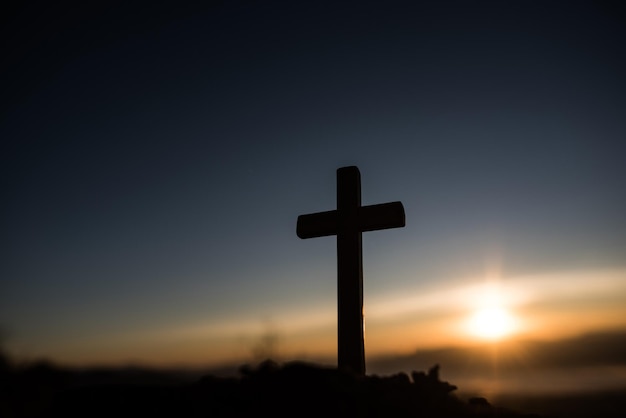 silhouette cross against sky during sunset