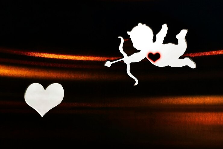 फोटो silhouette of a cupid and a heart on the dark background