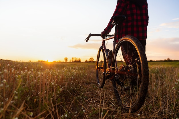 Silhouette of a cyclist and his bike against the sunset sky background. 