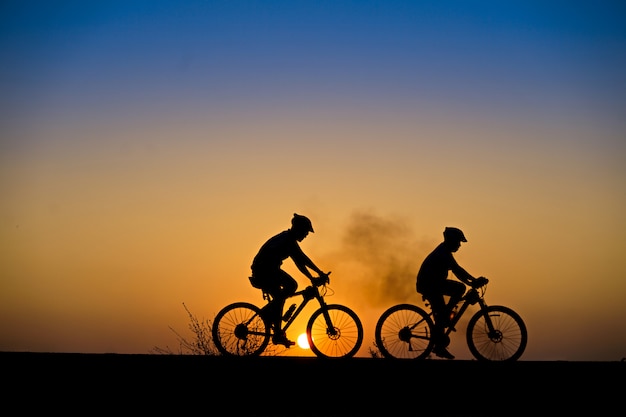 Силуэт велосипедиста с горным велосипедом на красивое время заката