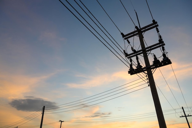 Silhouette di poli elettrici e fili elettrici al tramonto di sera poli elettrici ad alta tensione nel bel cielo