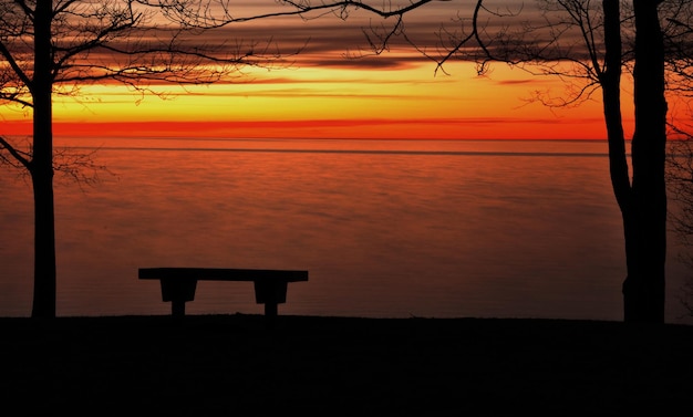 Foto silhouette di una panchina vuota sulla spiaggia