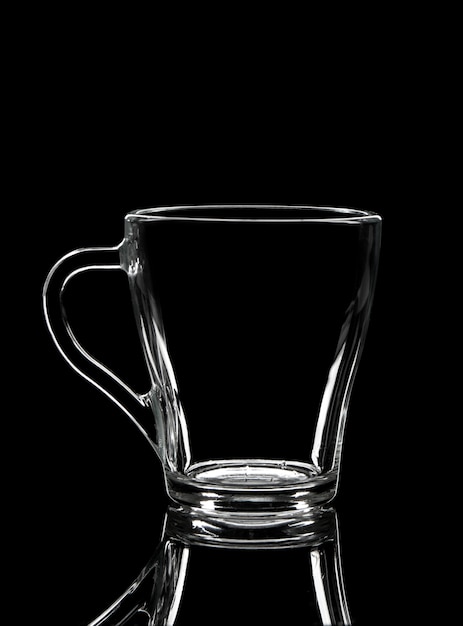 Silhouette of empty glass cup on black