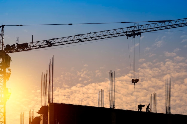 Silhouette engineer standing orders construction crew working\
on high ground