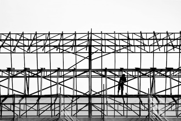 Silhouette of engineer standing to work safely on high structure of the building