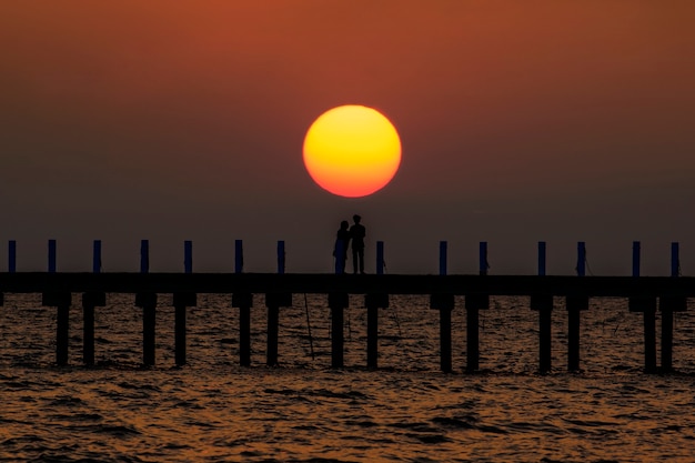 Sagoma la sera sulla spiaggia cielo arancione di estate