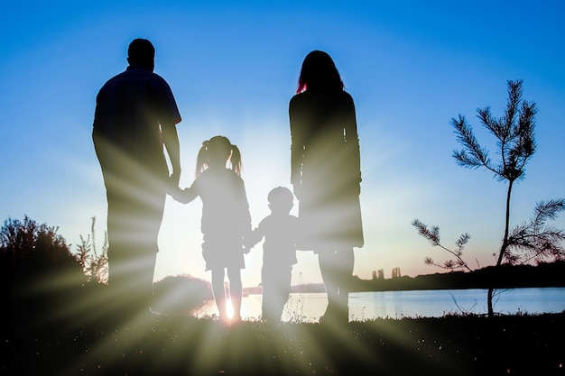 Silhouette family including his father mother and two children in the hands of