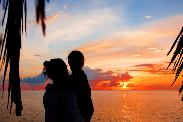 Foto silhouette di padre e figlia sulla spiaggia al tramonto. tramonto
