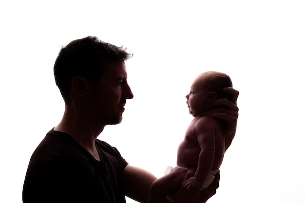 Silhouette of a father holding his newborn baby