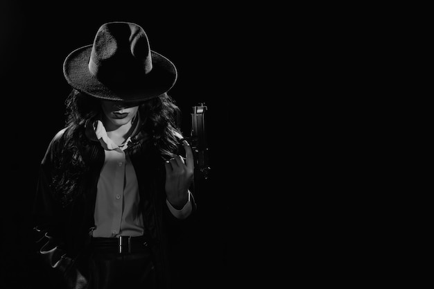 Foto silhouette di una detective donna in cappotto e cappello con una pistola in mano drammatico ritratto noir nello stile di libri e film polizieschi dell'istantanea in bianco e nero degli anni '50