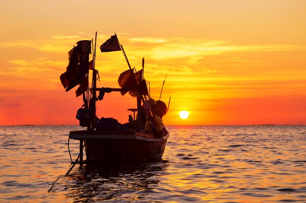 silhouette of fisherman boat with during sunset in Thailand