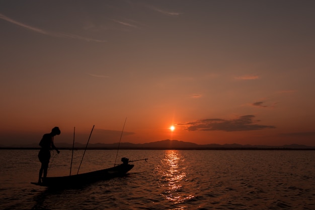 Silhouette of fisherman  on the lake 