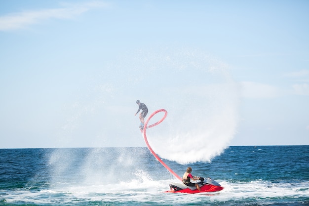 Silhouette di un pilota di fly board in mare