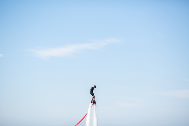 Foto silhouette di un pilota di flyboard in mare