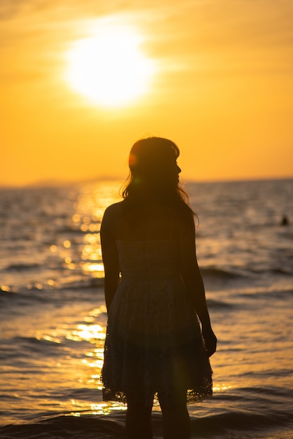 Silhouette of free woman enjoying freedom feeling happy on the beach.