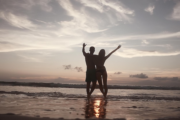 友達のシルエット夕焼け海夏/夏の若い友達のグループ男性と女性は休憩して海で楽しんで、幸せな海の夕日