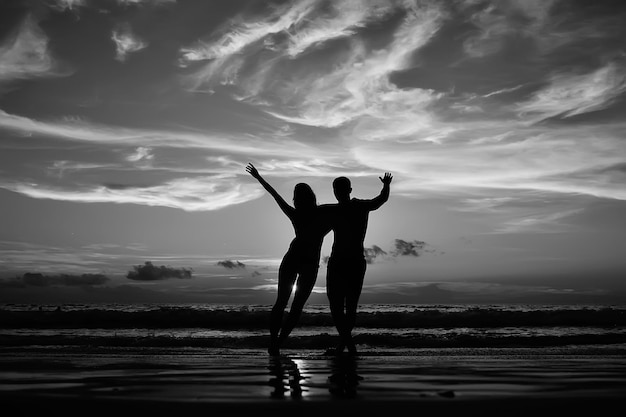 Silhouette of friends sunset sea summer / group of young\
friends men and women in summer have a rest and have fun on the\
sea, happy sea sunset