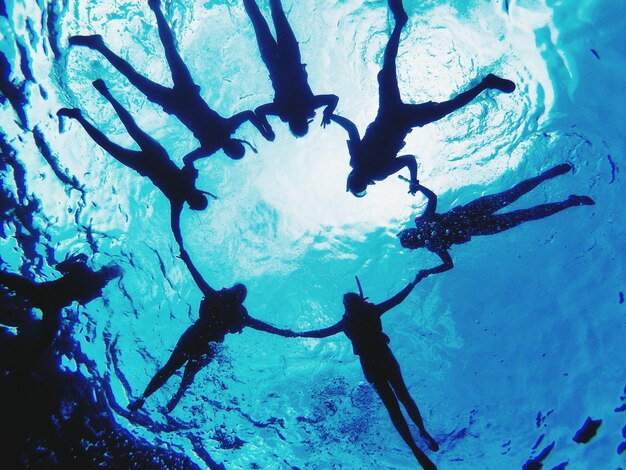 Foto silhouette amici che nuotano in mare