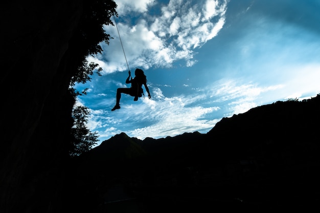 Foto silhouette di una ragazza che scende dalla corda dopo l'arrampicata