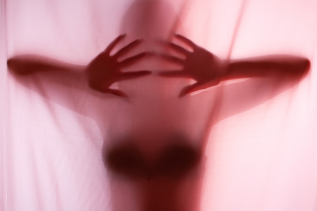 Silhouette of girl behind a curtain. Abstract and blurred image of a girl