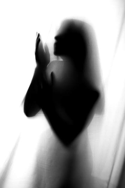 Silhouette of girl behind a curtain. Abstract and blurred image of a girl