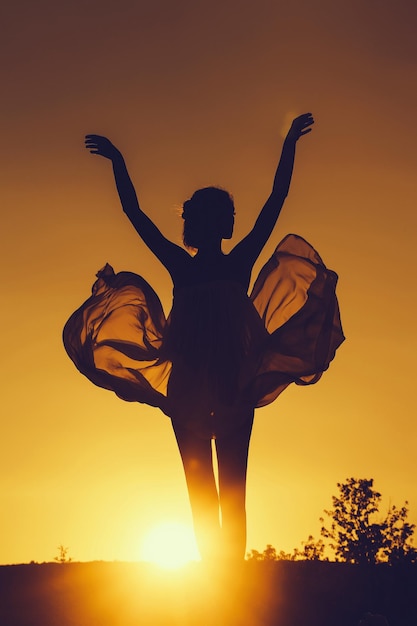 Photo silhouette of girl over sunset