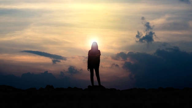 Siluetta di una ragazza che guarda il tramonto