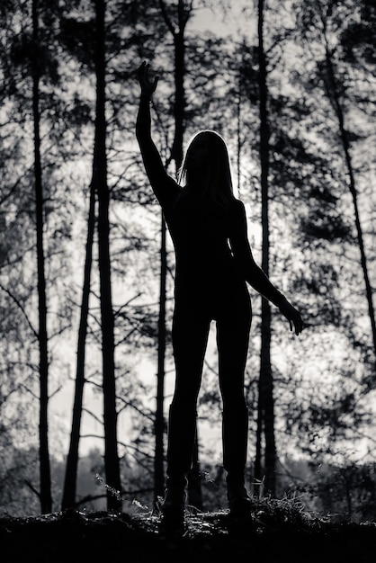 Silhouette di una ragazza con un bel corpo nella foresta