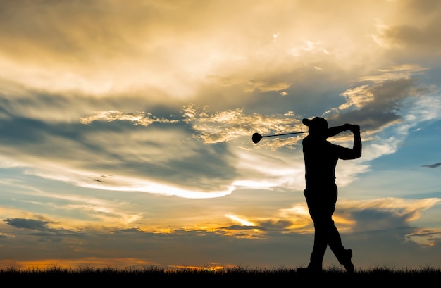 Foto giocatore di golf della siluetta che gioca golf durante il bello tramonto